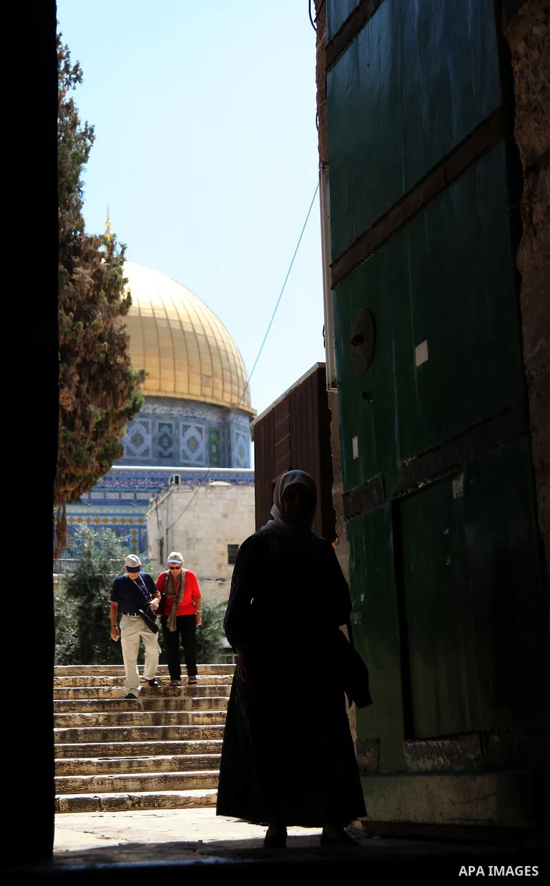 A Palestinian woman walks at the al-Aqsa mosque compound, Islam's third holiest site, in the Old City of Jerusalem on June 12, 2014. Shops were shuttered in East Jerusalem on Thursday to show solidarity with hundreds of...