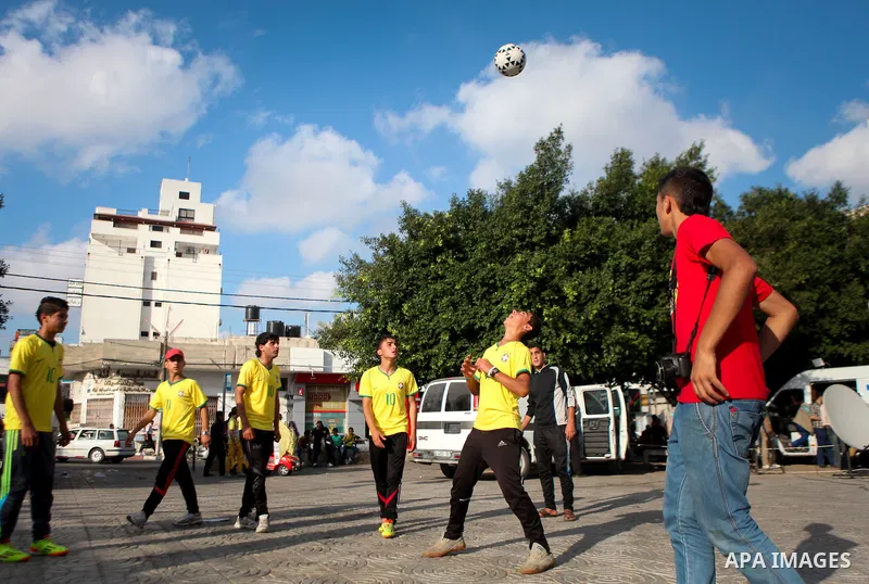 Palestinian youth take part in a football match during a protest against the Israeli blockade on Gaza Strip, in Gaza City on June 12, 2014. Palestinians share a billion or more people around the globe the feeling of anti...