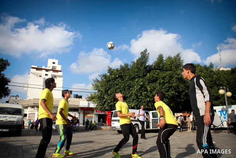 Palestinian youth take part in a football match during a protest against the Israeli blockade on Gaza Strip, in Gaza City on June 12, 2014. Palestinians share a billion or more people around the globe the feeling of anti...
