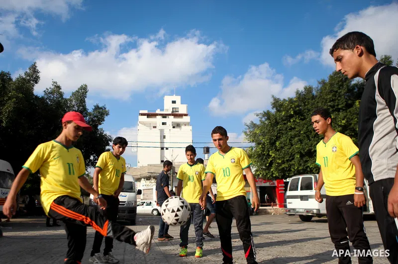 Palestinian youth take part in a football match during a protest against the Israeli blockade on Gaza Strip, in Gaza City on June 12, 2014. Palestinians share a billion or more people around the globe the feeling of anti...