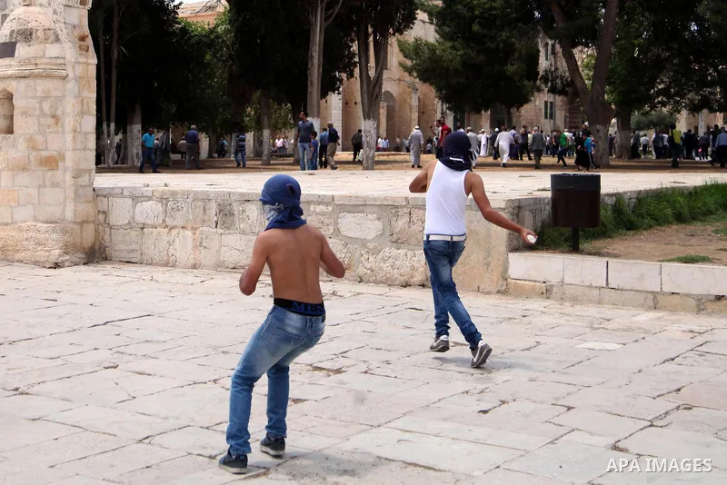 Palestinian youth throw stones at Israeli riot police during clashes following Friday prayers at the al-Aqsa mosque compound in Jerusalem's Old City on June 13, 2014. Photo by Saeed Qaq