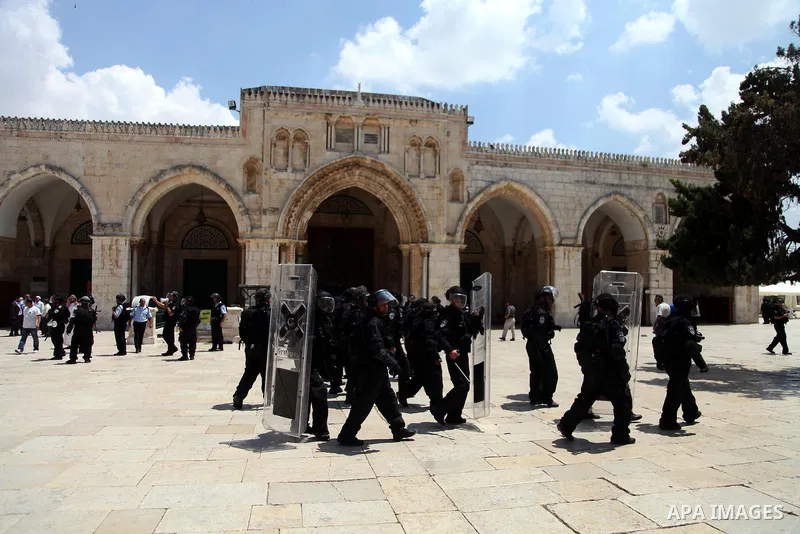 Israeli riot police walk in front of al-Aqsa mosque during clashes with Palestinian youths following Friday prayers at the al-Aqsa mosque compound in Jerusalem's Old City on June 13, 2014. Photo by Saeed Qaq