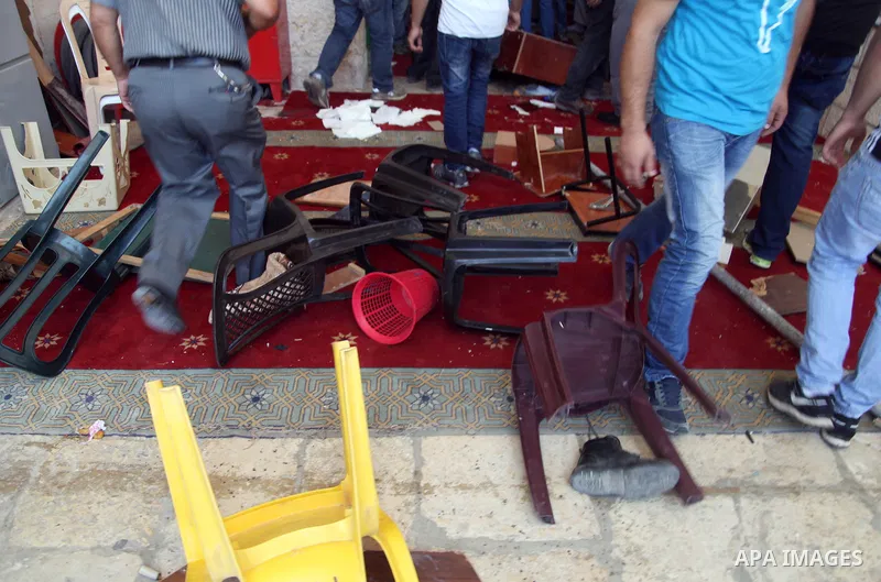 Palestinians inspect the furniture of al-Aqsa mosque during clashes with Israeli riot police following Friday prayers at the al-Aqsa mosque compound in Jerusalem's Old City on June 13, 2014. Photo by Saeed Qaq