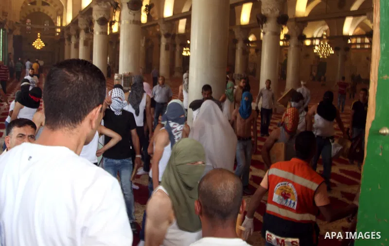 Palestinian youths shelters at al-Aqsa mosque during clashes with Israeli riot police following Friday prayers at the al-Aqsa mosque compound in Jerusalem's Old City on June 13, 2014. Photo by Saeed Qaq