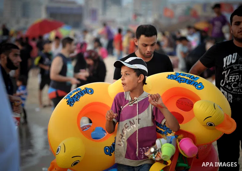 A Palestinian boy sells games at the beach in Gaza city, on June 13, 2014. Friday is the Muslim holiday and as summer is entering many Palestinian people go to the beach since it is the major entertainment area in the Ga...