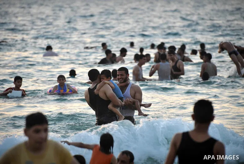 Palestinians enjoy a summer day at the beach in Gaza city, on June 13, 2014. Friday is the Muslim holiday and as summer is entering many Palestinian people go to the beach since it is the major entertainment area in the...
