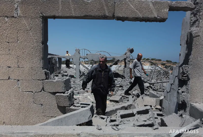 Palestinian men inspect the sites of an Israeli air strike in Rafah in the southern Gaza Strip June 15, 2014. Israeli strikes come only three days after Israeli air forces targeted a Palestinian individual associated wit...