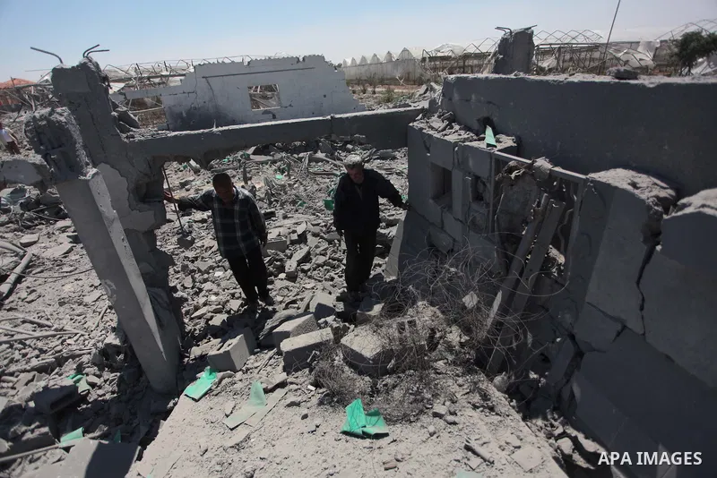 Palestinian men inspect the sites of an Israeli air strike in Rafah in the southern Gaza Strip June 15, 2014. Israeli strikes come only three days after Israeli air forces targeted a Palestinian individual associated wit...