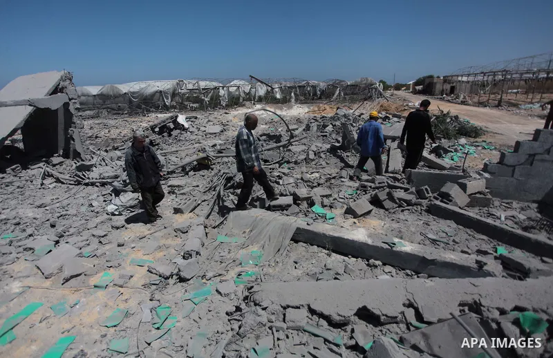 Palestinian men inspect the sites of an Israeli air strike in Rafah in the southern Gaza Strip June 15, 2014. Israeli strikes come only three days after Israeli air forces targeted a Palestinian individual associated wit...