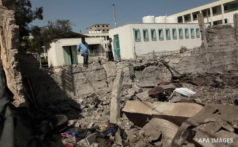 A Palestinian man looks on the rubble past a crater following an air strike by the Israeli airforce on Gaza City, on June 16, 2014. Israel launched air strikes on different areas of on Gaza Strip, as Israeli troops kille...