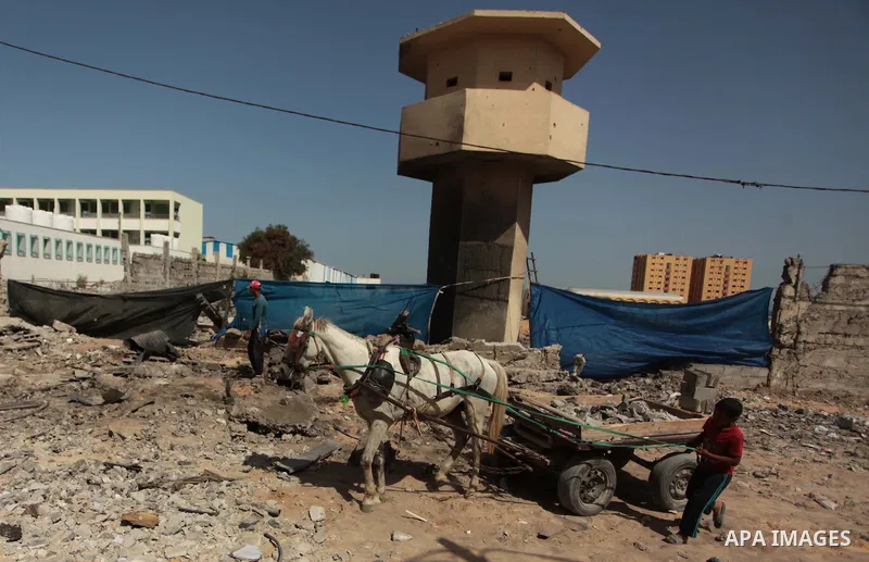 Palestinian boys collect rubbles around a crater following an air strike by Israeli airforce on Gaza City on June 16, 2014. Israel launched air strikes on different areas of on Gaza Strip, as Israeli troops killed a Pale...