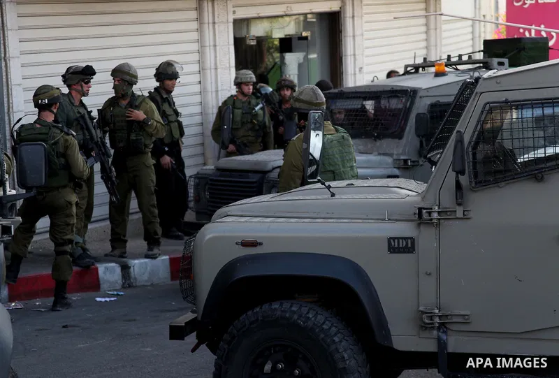 Israeli soldiers stand guard at a checkpoint in the West Bank town of Hebron on June 16, 2014. Israeli Prime Minister Benjamin Netanyahu has said that the Jewish youths were kidnapped in the West Bank by a terrorist orga...