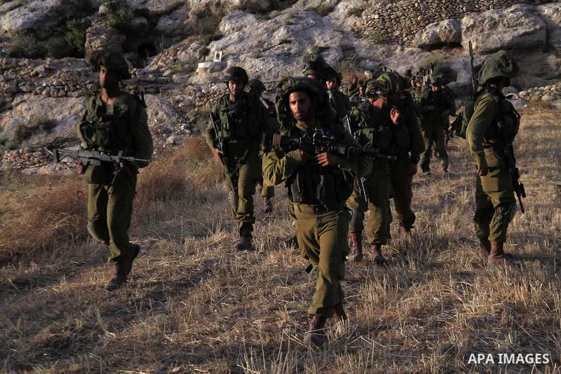 Israeli troops take part in a search operation on the outskirts of the West Bank town of Hebron on June 16,2014 as security forces broadened the search for three teenagers believed kidnapped by Palestinian militants and...