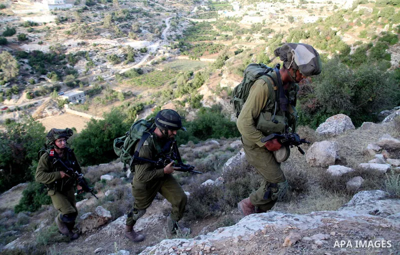 Israeli troops take part in a search operation on the outskirts of the West Bank town of Hebron on June 16,2014 as security forces broadened the search for three teenagers believed kidnapped by Palestinian militants and...