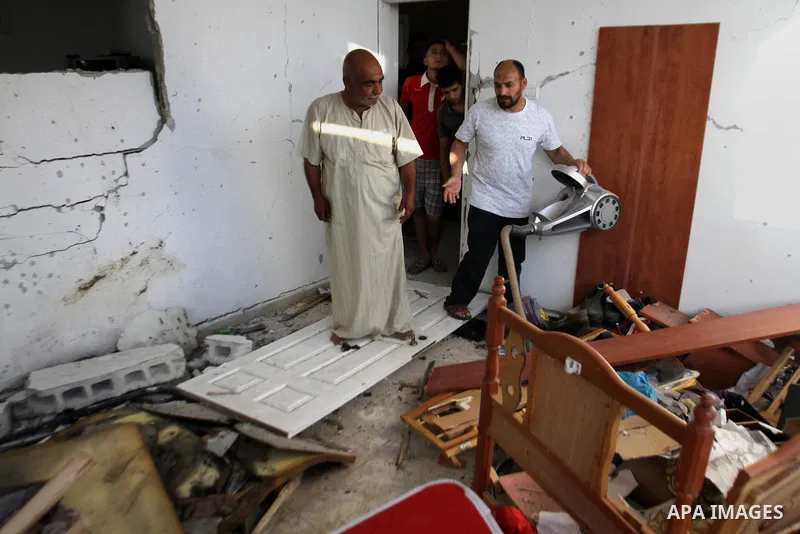 Palestinian men inspect the damage after their house was searched by Israeli forces on June 17, 2014 at the Balata refugee camp, close to the northern West Bank city of Nablus. Large numbers of Israeli soldiers raided th...