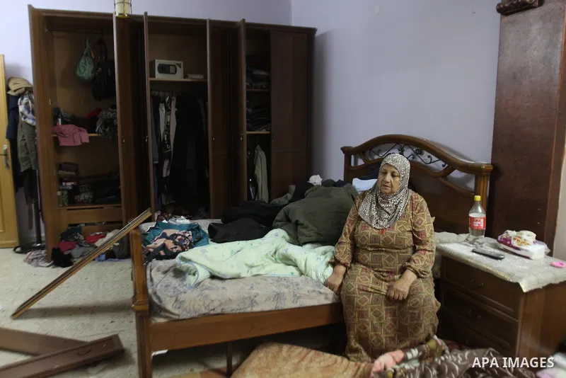 Palestinian Mother of Eyad Terawe checks the damage to her family home after Israeli troops arrest her son at the Balata refugee camp near the West Bank city of Nablus, 17 June 2014. Large numbers of Israeli soldiers rai...