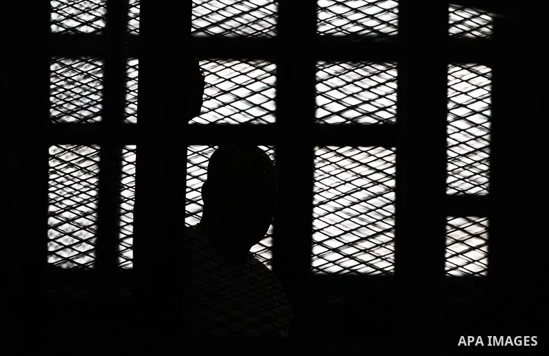 Egyptian Muslim Brotherhood members stand inside the defendants cage during their trial in the capital Cairo on June 17, 2014. The court postponed to July 23 the verdict in the trial of Muslim Brotherhood Supreme Guide M...