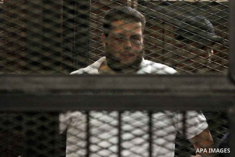 Egyptian Muslim Brotherhood members stand inside the defendants cage during their trial in the capital Cairo on June 17, 2014. The court postponed to July 23 the verdict in the trial of Muslim Brotherhood Supreme Guide M...