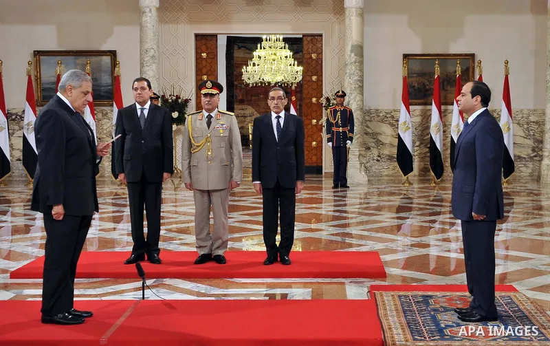 A handout picture released by Egyptian Presidency shows Egyptian President Abdel-Fattah el-Sissi, right, listens to the new ministers during a swearing-in ceremony for new cabinet ministers at the presidential palace in...