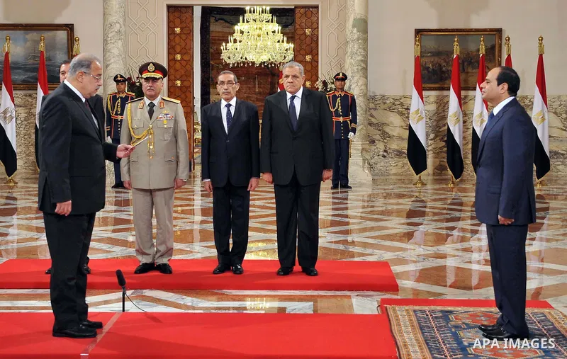 A handout picture released by Egyptian Presidency shows Egyptian President Abdel-Fattah el-Sissi, right, listens to the new ministers during a swearing-in ceremony for new cabinet ministers at the presidential palace in...