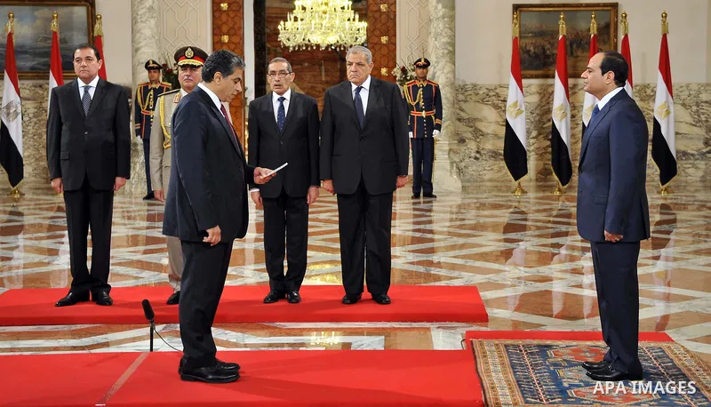 A handout picture released by Egyptian Presidency shows Egyptian President Abdel-Fattah el-Sissi, right, listens to the new ministers during a swearing-in ceremony for new cabinet ministers at the presidential palace in...
