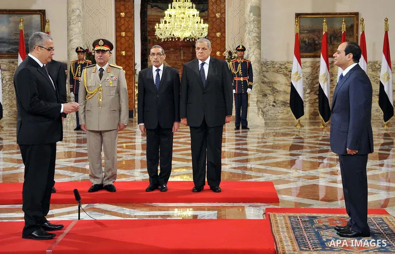 A handout picture released by Egyptian Presidency shows Egyptian President Abdel-Fattah el-Sissi, right, listens to the new ministers during a swearing-in ceremony for new cabinet ministers at the presidential palace in...