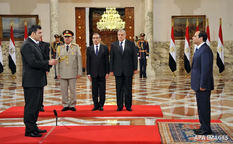 A handout picture released by Egyptian Presidency shows Egyptian President Abdel-Fattah el-Sissi, right, listens to the new ministers during a swearing-in ceremony for new cabinet ministers at the presidential palace in...