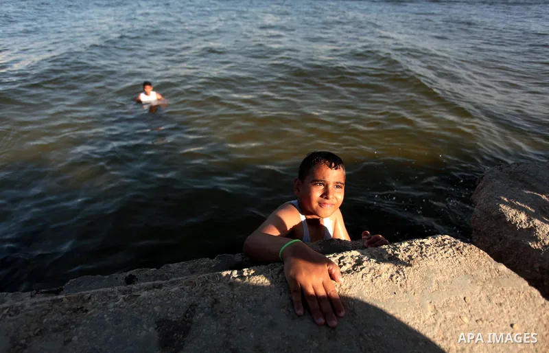 Palestinian youths enjoy swimming at the beach of Gaza City, on June 17, 2014. Photo by Ashraf Amra