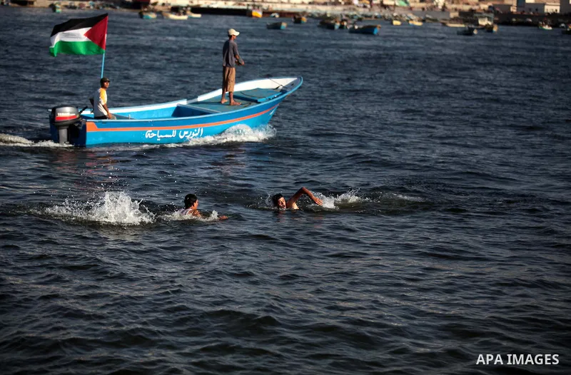Palestinian youths enjoy swimming at the beach of Gaza City, on June 17, 2014. Photo by Ashraf Amra
