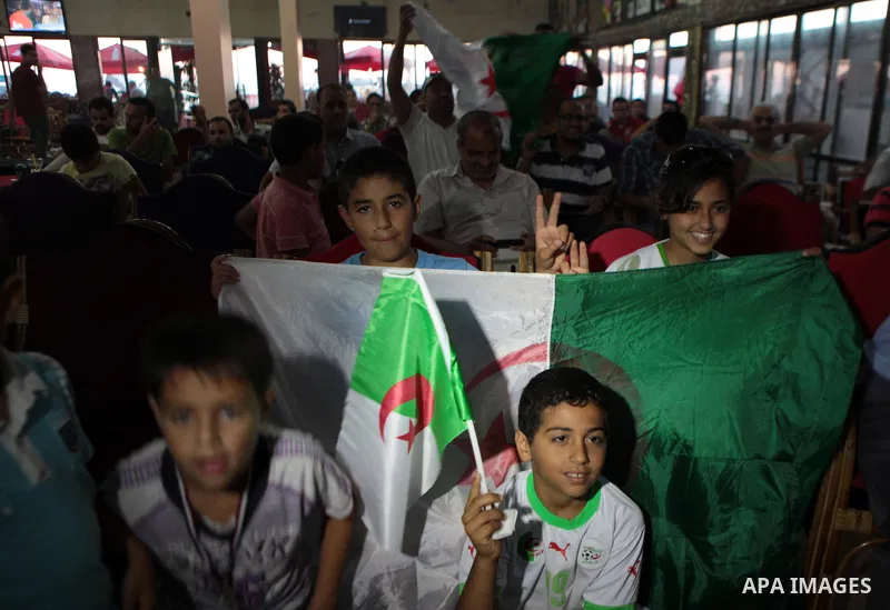 Palestinian children wave Algerian flag as they watch the match between Algeria and Belgium during the 2014 FIFA World Cup in Brazil, on June 17, 2014 in a cafe in Gaza City. Photo by Ezz Zanoun