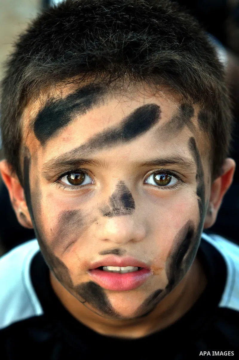 A Palestinian boy poses for a photograph as he participates in a march to show solidarity with Palestinian prisoners held in Israeli jails, in Gaza City on June 18, 2014. Some 285 Palestinian prisoners are observing a ma...