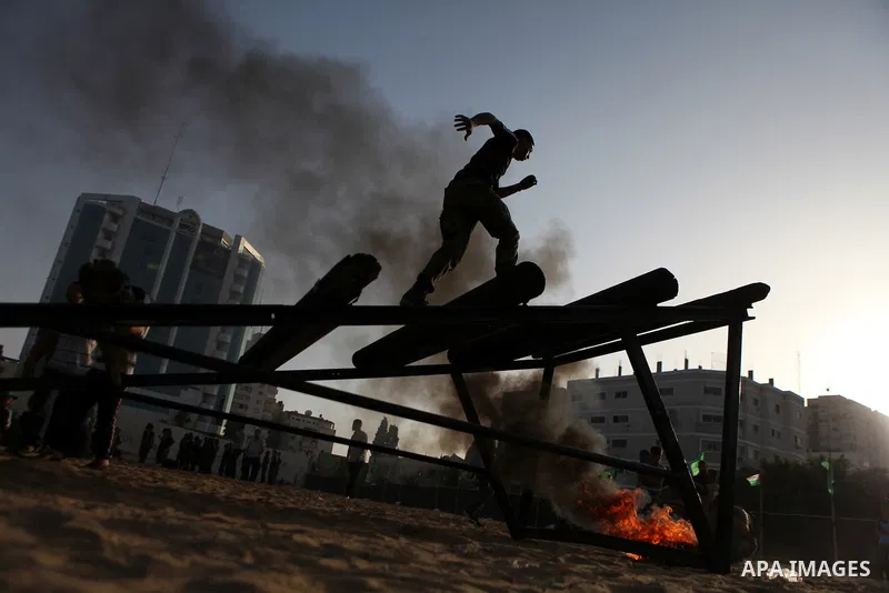 A Palestinian youth demonstrates his skills during a graduation ceremony of a military-style summer camp organized by the Hamas movement in Gaza City June 19, 2014. Hamas stages dozens of military-style summer camps for...