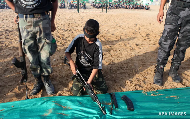 Palestinian youths demonstrate their skills during a graduation ceremony of a military-style summer camp organized by the Hamas movement in Gaza City June 19, 2014. Hamas stages dozens of military-style summer camps for...