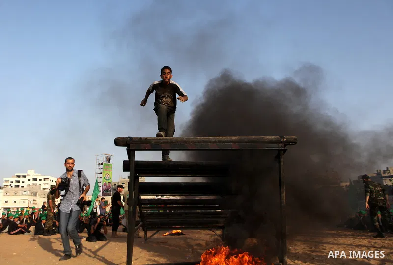 A Palestinian youth demonstrates his skills during a graduation ceremony of a military-style summer camp organized by the Hamas movement in Gaza City June 19, 2014. Hamas stages dozens of military-style summer camps for...