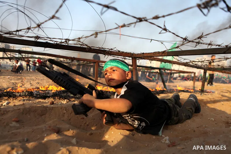 A Palestinian boy demonstrates his skills during a graduation ceremony of a military-style summer camp organized by the Hamas movement in Gaza City June 19, 2014. Hamas stages dozens of military-style summer camps for yo...
