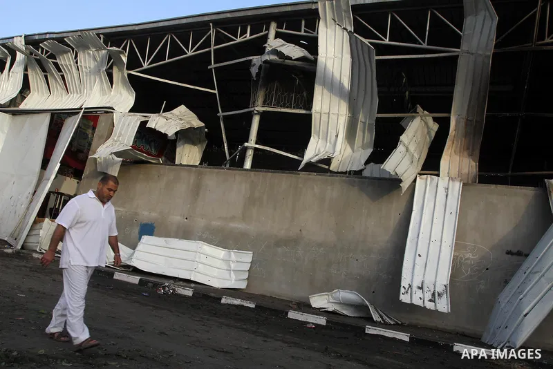 A Palestinian man inspects a food store following an Israeli air-strike in Gaza City on June 20, 2014. The Israeli army’s air force has conducted several air raids on the besieged Gaza Strip, leaving at least seven Pales...
