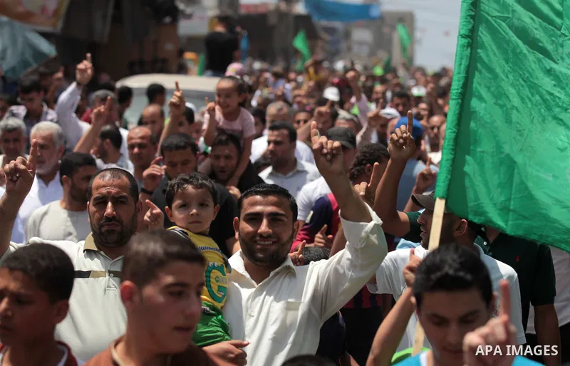 Palestinian Hamas supporters take part in a demonstration in solidarity with prisoners held in Israeli jails, and in support of the people in the West Bank, in Nuseirat refugee camp in the center of the Gaza Strip, June...