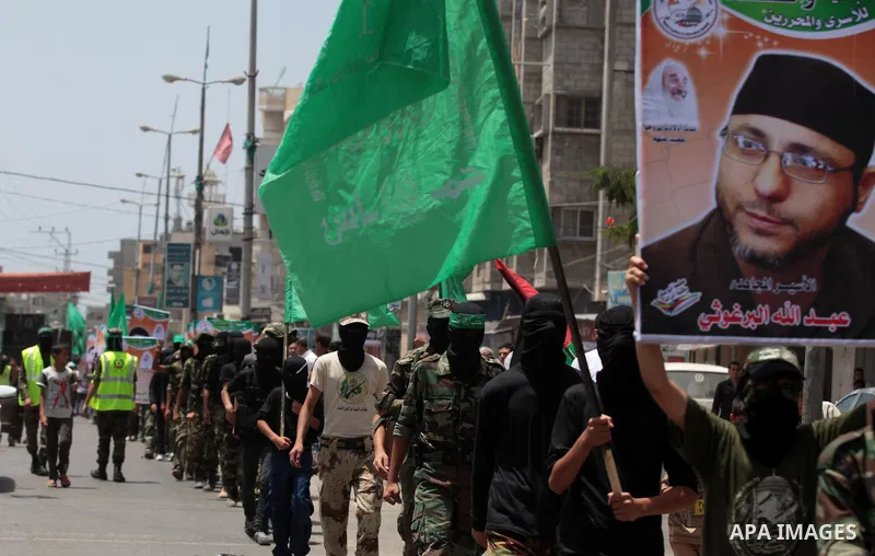 Palestinian Hamas militants take part in a demonstration in solidarity with prisoners held in Israeli jails, and in support of the people in the West Bank, in Nuseirat refugee camp in the center of the Gaza Strip, June 2...