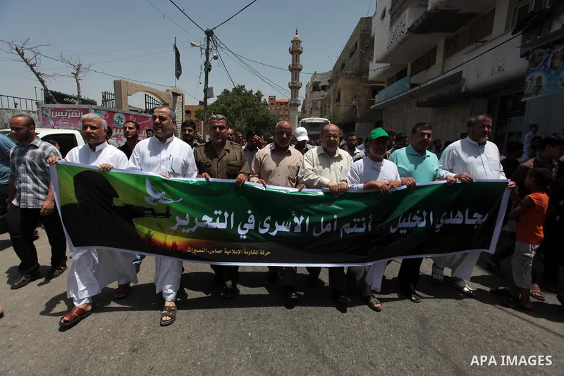 Palestinian Hamas supporters take part in a demonstration in solidarity with prisoners held in Israeli jails, and in support of the people in the West Bank, in Nuseirat refugee camp in the center of the Gaza Strip, June...