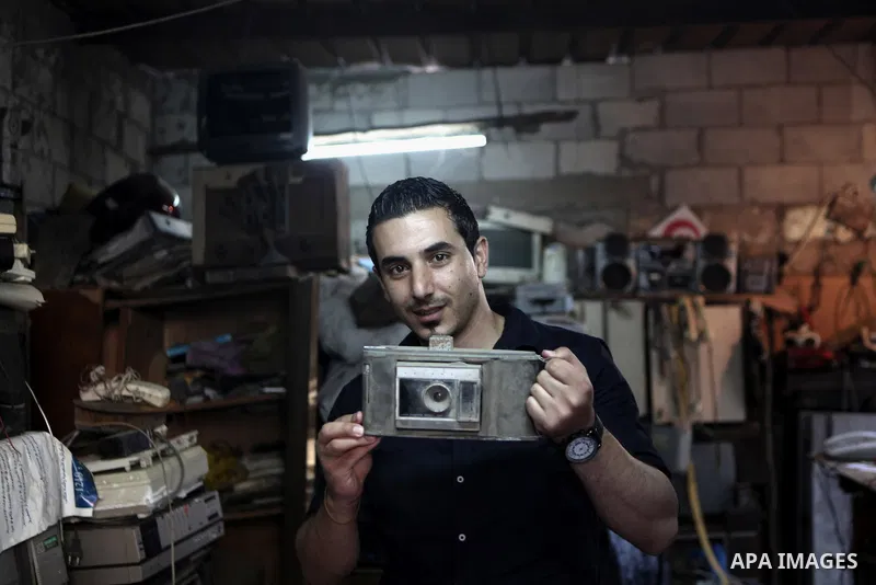 A Palestinian youth hold old camera in Gaza city on June 21, 2014. Photo by Ezz Zanoun