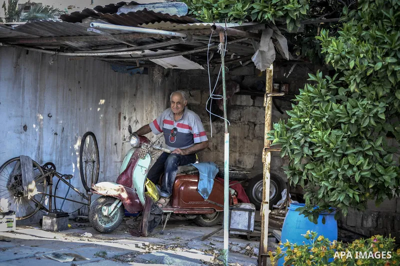 An elderly Palestinian man owns old instruments at his home in Gaza city on June 21, 2014. Photo by Ezz Zanoun