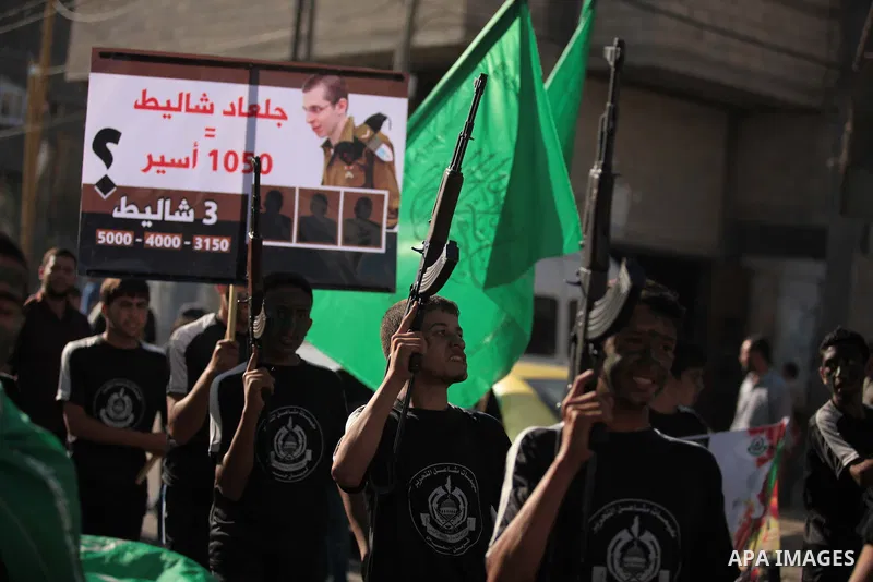 Palestinian children hold weapons and pictures of Gilad Shalit, a former Israel defense forces soldier who was kidnapped by Hamas in 2006, during a rally in solidarity with the hunger-striking Palestinian prisoners held...