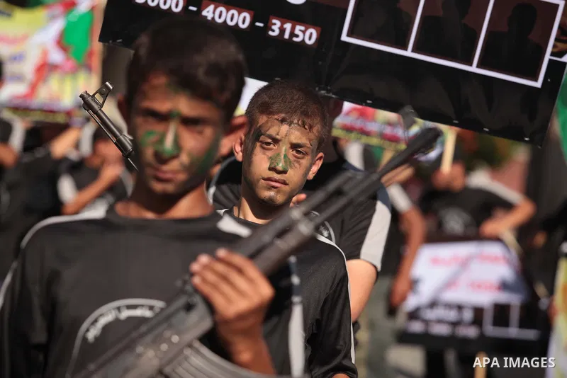 Palestinian children hold weapons during a rally in solidarity with the hunger-striking Palestinian prisoners held by Israel, in Jabalia refugee camp in the northern Gaza Strip, June 24, 2014. Nearly 300 Palestinian pris...