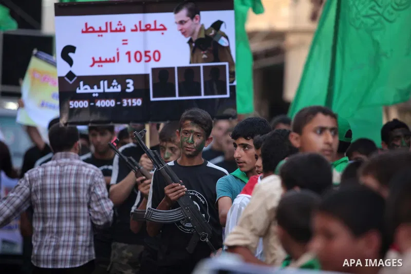 Palestinian children hold weapons and pictures of Gilad Shalit, a former Israel Defense Forces soldier who was kidnapped by Hamas in 2006, during a rally in solidarity with the hunger-striking Palestinian prisoners held...