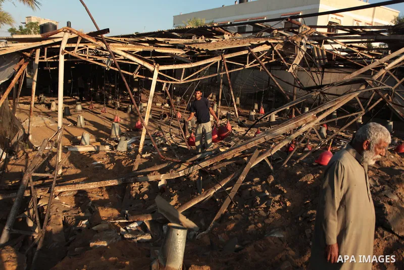 Palestinian men inspect a chicken coop damaged in an Israeli air strike in Khan Younis in the southern Gaza Strip June 25, 2014. Militants in the Gaza Strip, a coastal enclave where Hamas is dominant and has vowed reveng...
