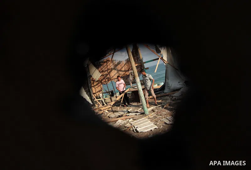 Palestinian men inspect the site of an Israeli air strike in the central Gaza Strip June 25, 2014. Militants in the Gaza Strip, a coastal enclave where Hamas is dominant and has vowed revenge at Israel's crackdown, fired...