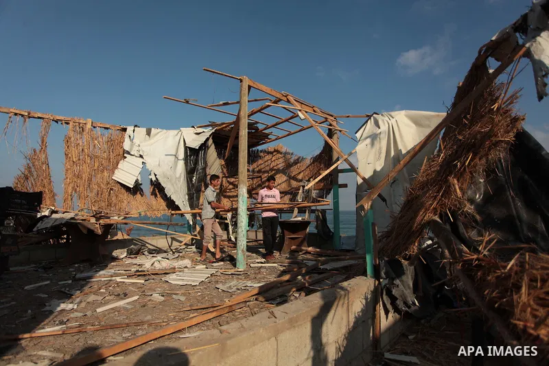 Palestinian men inspect the site of an Israeli air strike in the central Gaza Strip June 25, 2014. Militants in the Gaza Strip, a coastal enclave where Hamas is dominant and has vowed revenge at Israel's crackdown, fired...