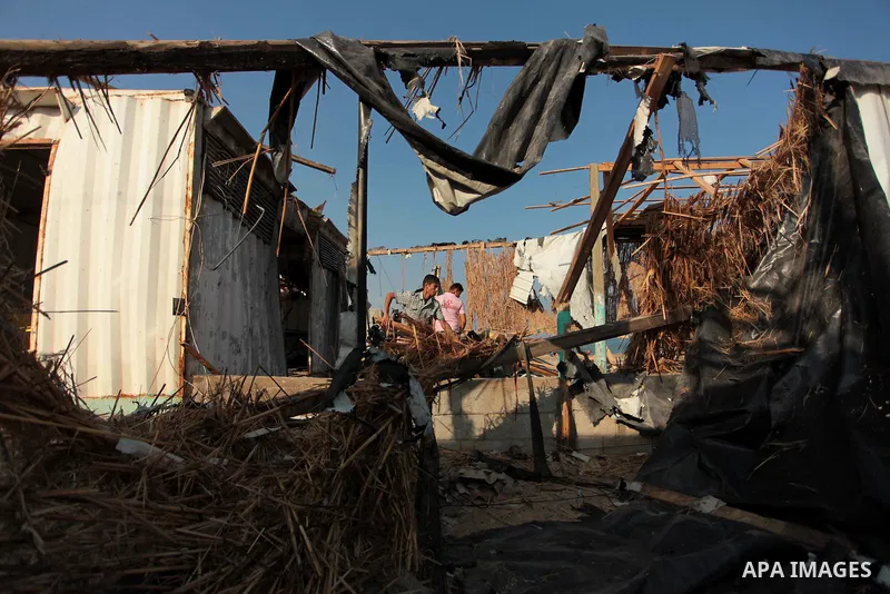Palestinian men inspect the site of an Israeli air strike in the central Gaza Strip June 25, 2014. Militants in the Gaza Strip, a coastal enclave where Hamas is dominant and has vowed revenge at Israel's crackdown, fired...