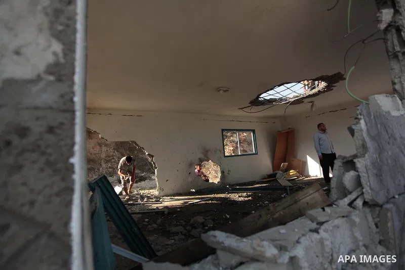 Palestinian men inspect the site of an Israeli air strike in the central Gaza Strip June 25, 2014. Militants in the Gaza Strip, a coastal enclave where Hamas is dominant and has vowed revenge at Israel's crackdown, fired...