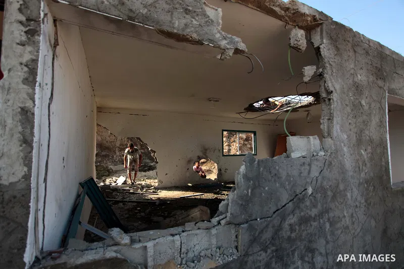 Palestinian men inspect the site of an Israeli air strike in the central Gaza Strip June 25, 2014. Militants in the Gaza Strip, a coastal enclave where Hamas is dominant and has vowed revenge at Israel's crackdown, fired...